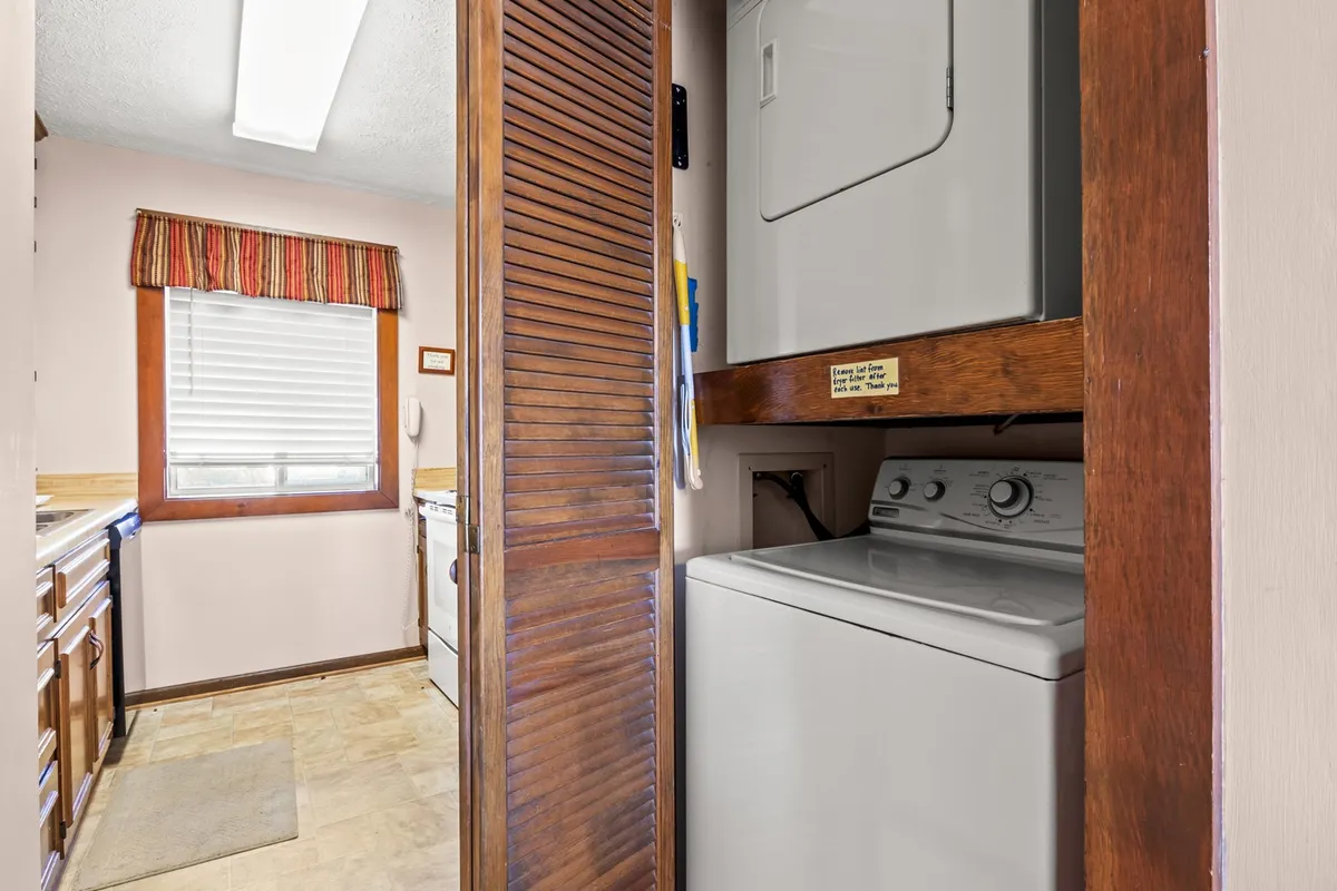 A functional area with washer and dryer, kitchen cabinets, and a window, emphasizing the practical conveniences available to guests for longer or more comfortable stays.